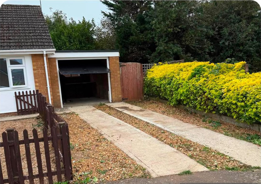 The same front garden cleared, with a trimmed hedge and an open path to the garage