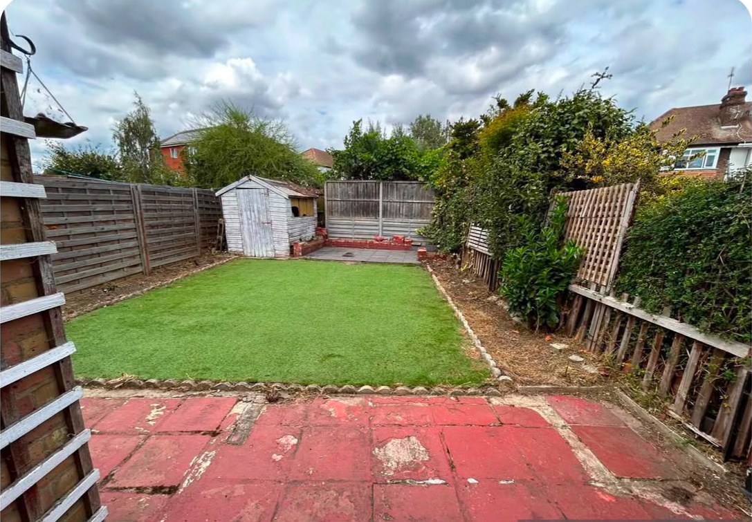 The same garden cleared, with a neat new lawn running down to the shed