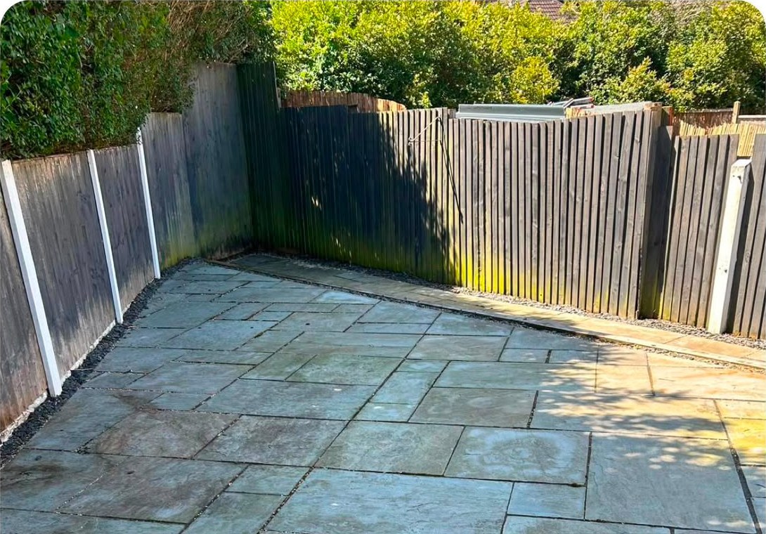 The same slate patio swept clear from fence to fence